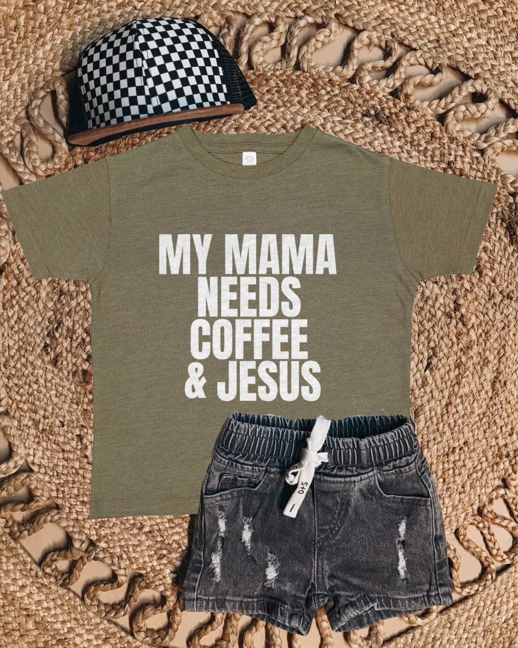 Children's outfit with t-shirt, shorts, and cap on a textured surface