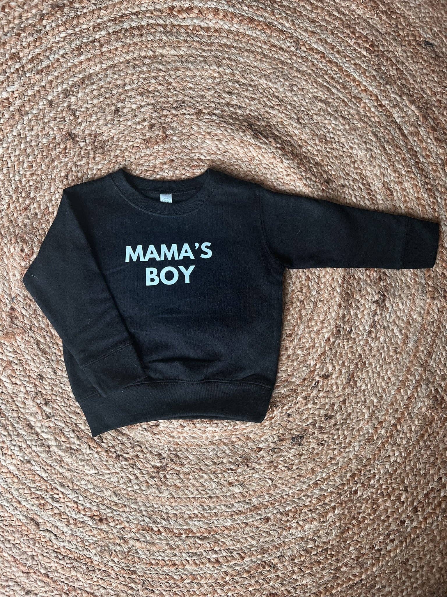 Black sweatshirt with 'MAMA'S BOY' text on a textured surface